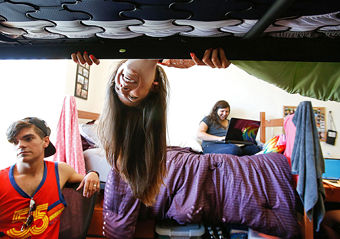 A female student (center) at Cal State Northridge looks under her bunk bed while inside her dorm room Aug. 26. Privacy Pop is a personal tent that can be pitched in a dorm room to add extra privacy.