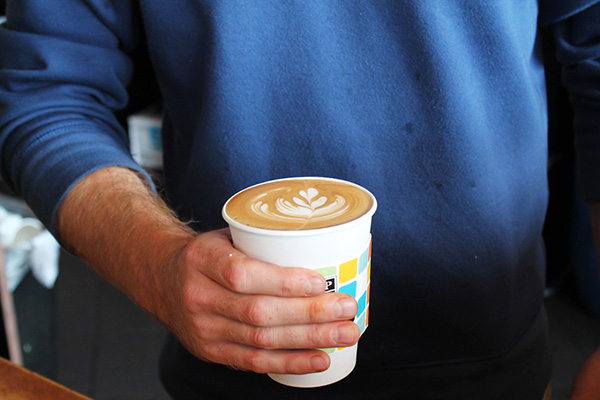 A customer holds a freshly brewed latte at Cup O Joe coffee shop in September 2015. Credit: Lantern File Photo