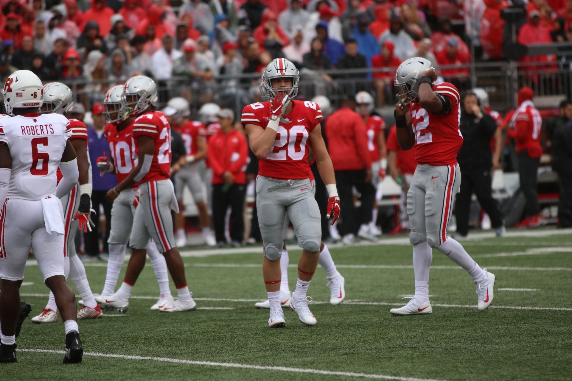Pete Werner walks on the field at Ohio Stadium with teammates in the background