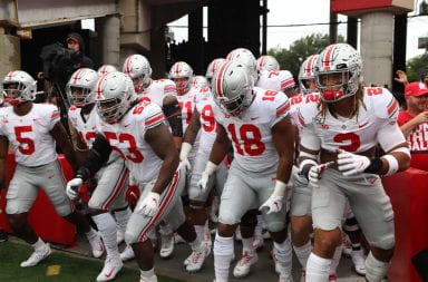Ohio State football players run onto the field to warm up before the road game against Nebraska.