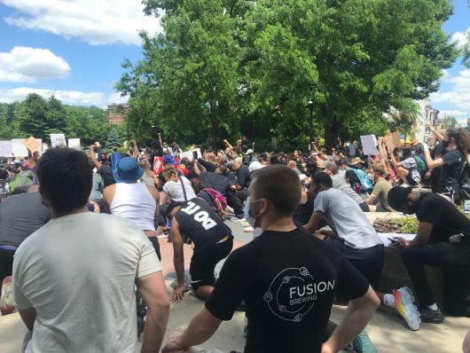 Protesters kneel in honor of George Floyd in downtown Cincinnati at Washington Park. | Courtesy of Amna Rustom