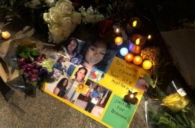 Candles and flowers are placed around pictures of Breonna Taylor
