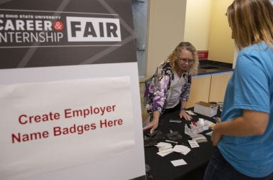 An Ohio State students reaches to make an employer name badge while at the 2019 Ohio State career fair