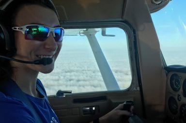 Jillian Bourdage sits in the pilot seat as she flies