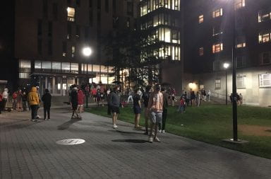 Students stand outside of a south campus dorm after being evacuated due to the smell of natural gas after midnight