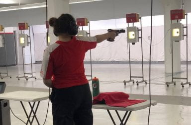 Emily aims her pistol at the target
