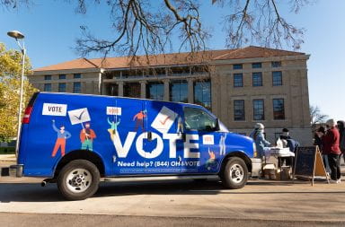 a blue truck that has the word vote written across the side of it