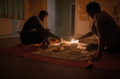 In a scene in "His House" Bol and Rial eat dinner on the floor in candle light