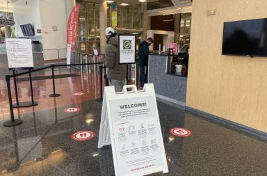 A sign at the entrance of the RPAC that says "Health passports will be checked for entry."