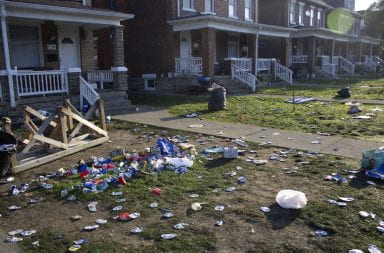 front yard with smashed beer cans, plastic cups and a flipped over wooden table