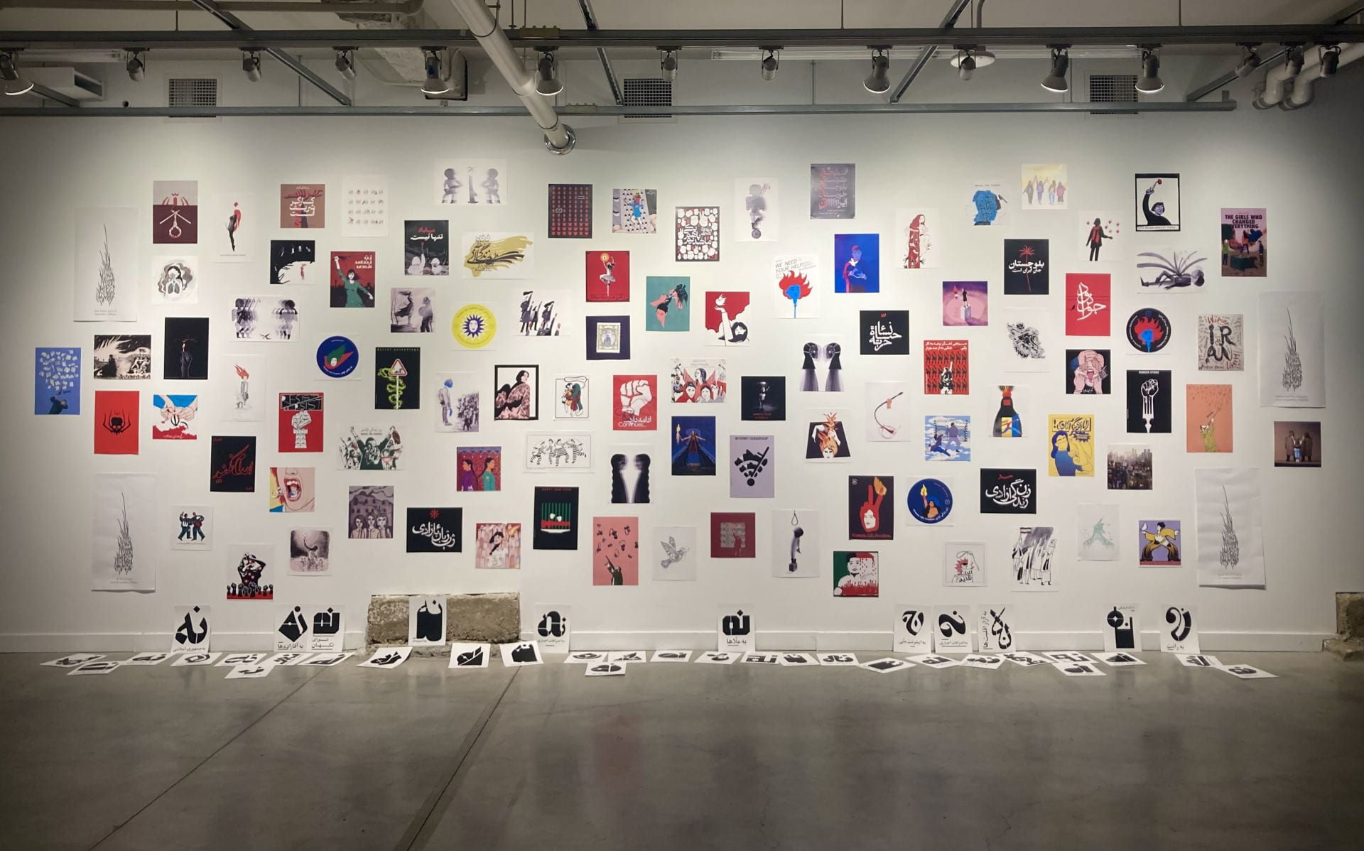 Posters designed by roughly 40 artists adorn a wall as part of the “Iran: Deciphering Violence and Resistance” exhibit, which is on show at the Urban Arts Space at the time of publication. Credit: Courtesy of Illya Mousavijad