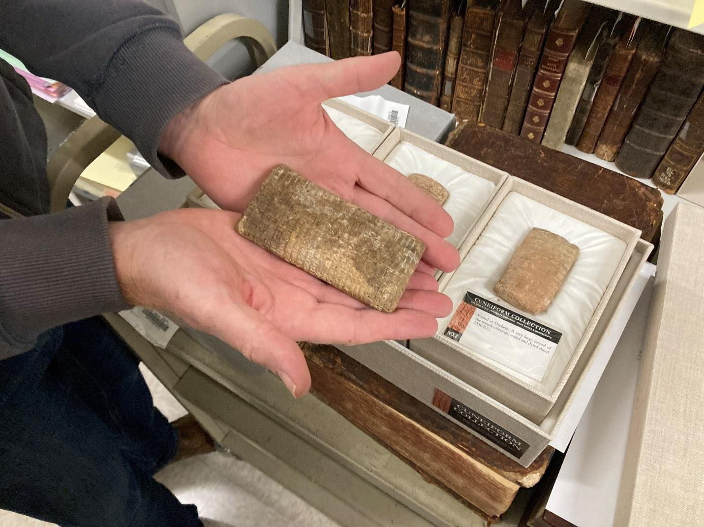 Eric Johnson, professor and curator of Thompson Special Collections, holds an ancient Babylonian clay tablet. Credit: Josh Farley