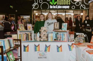 Co-founders and couple Reese Steiner (left) and Lauren Branch (right) behind the Little Gay Bookstore booth at the North Market in Bridge Park's annual Holiday Market, located in Dublin, Ohio, on Dec. 16. Credit: Abby Gongwer