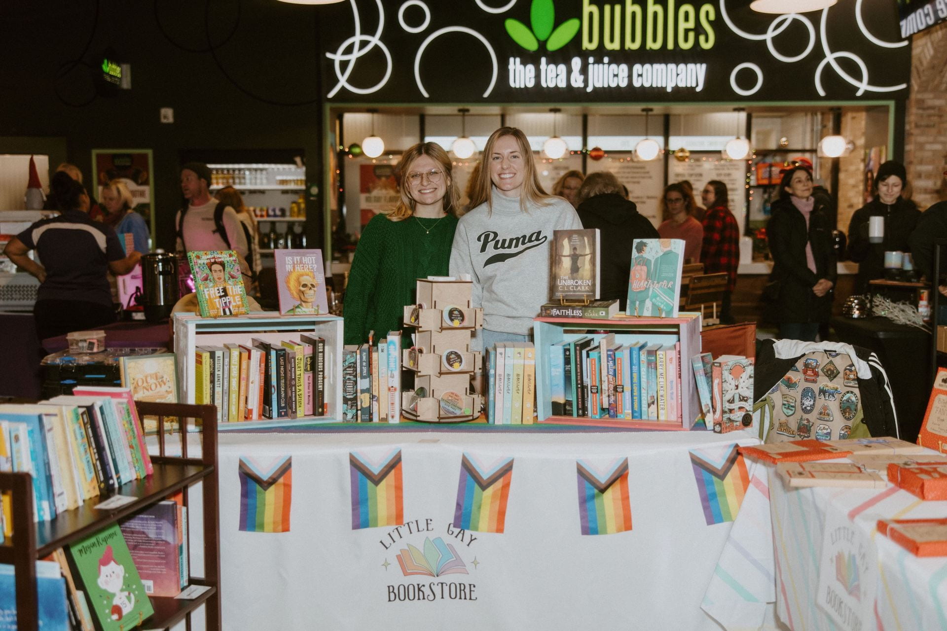Co-founders and couple Reese Steiner (left) and Lauren Branch (right) behind the Little Gay Bookstore booth at the North Market in Bridge Park's annual Holiday Market, located in Dublin, Ohio, on Dec. 16. Credit: Abby Gongwer