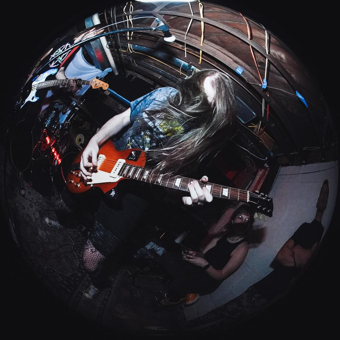 Violet Eadie, a guitarist in Columbus-based band Kill Gosling, plucks strings in the basement of Marlboro Manor on Sept. 24, 2023. Credit: Josh Brown