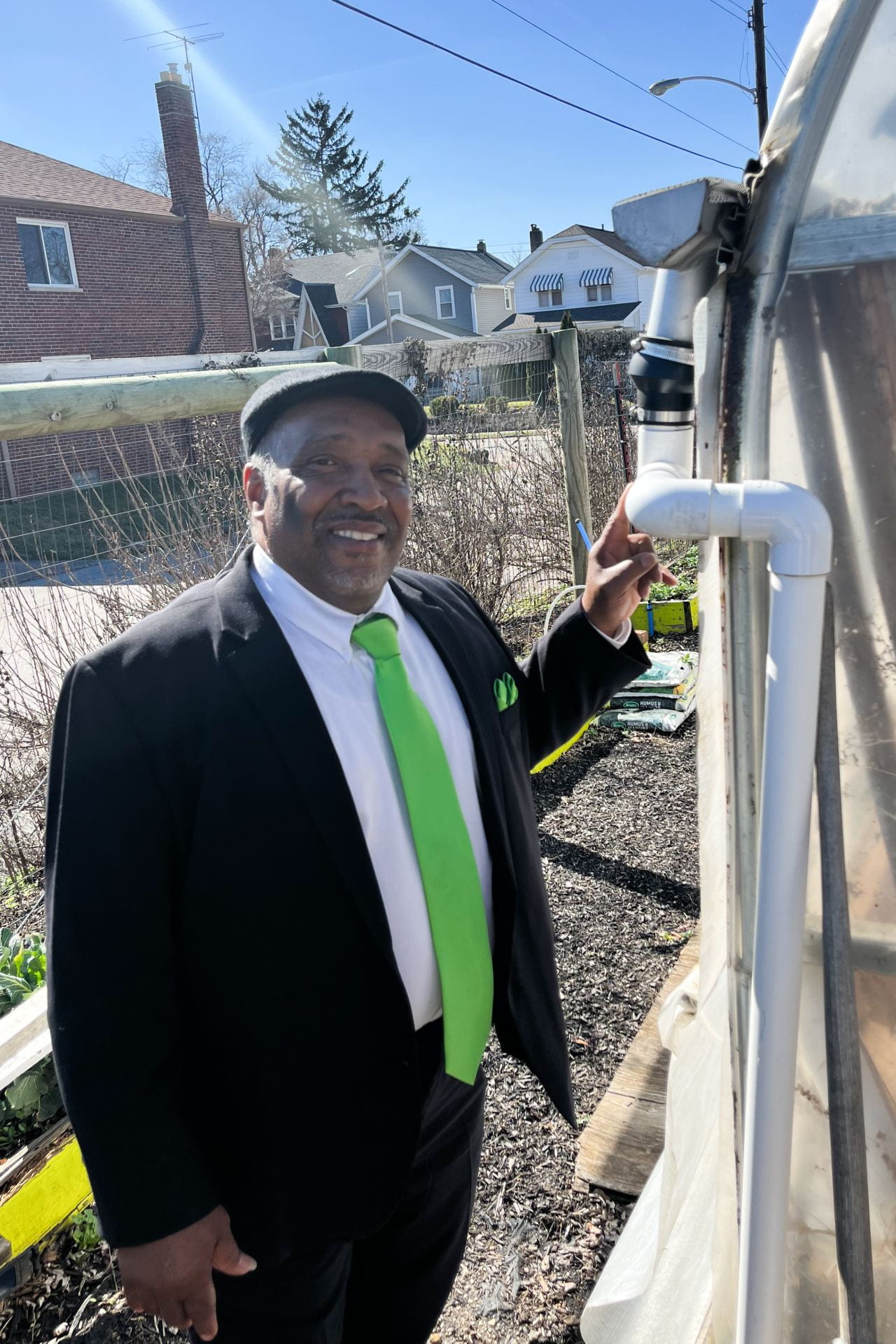 Aaron Hopkins, founder of South Side Family Farms, points to a rainwater catching system at one of his properties. Credit: Lauren Spirk | Lantern Reporter