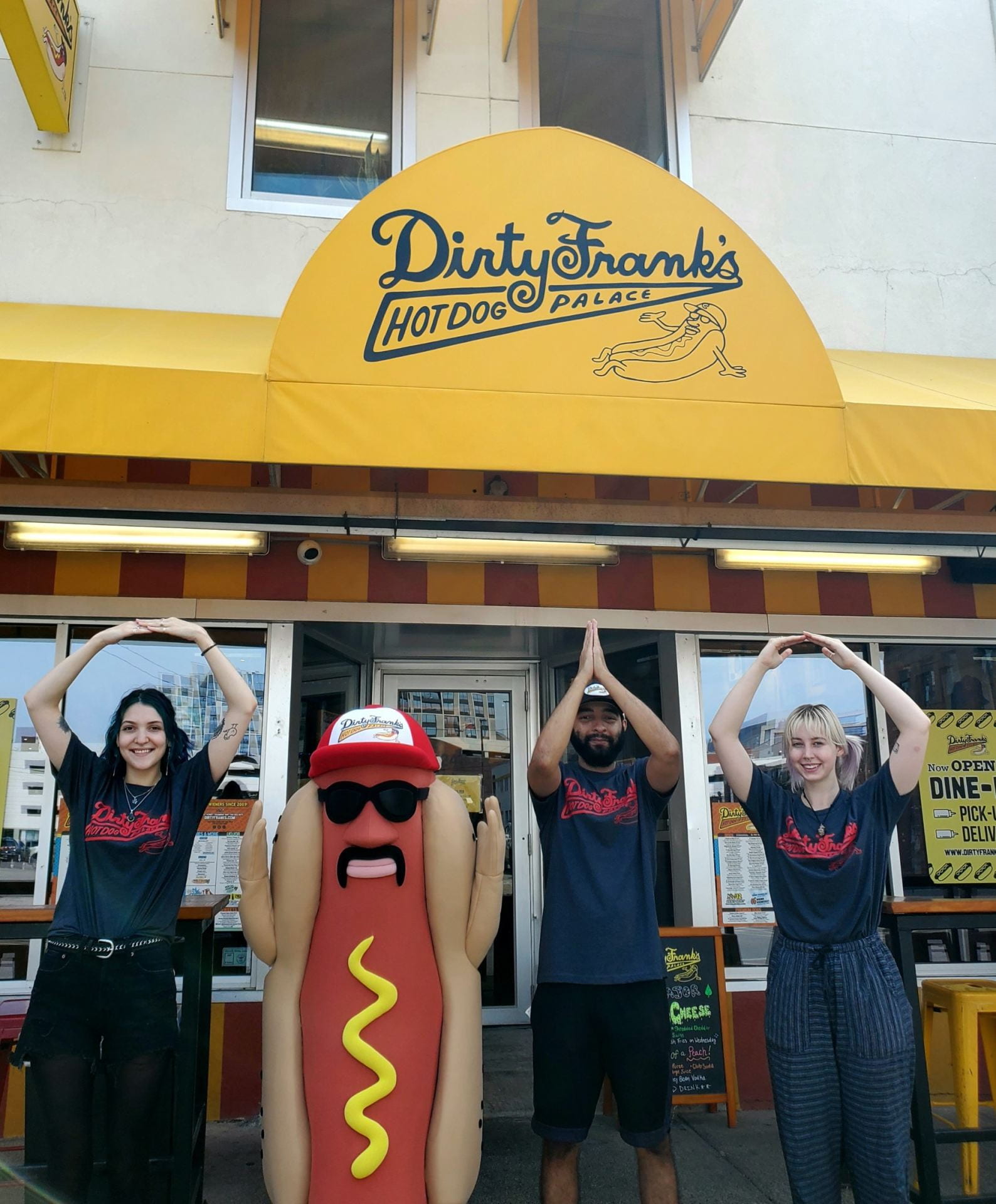 Dirty Frank’s Hot Dog Palace employees, along with the company mascot, partake in a well-known Ohio State tradition by spelling out “O-H-I-O" in front of one of the company’s numerous locations. Credit: Courtesy of Dirty Frank’s Hot Dog Palace