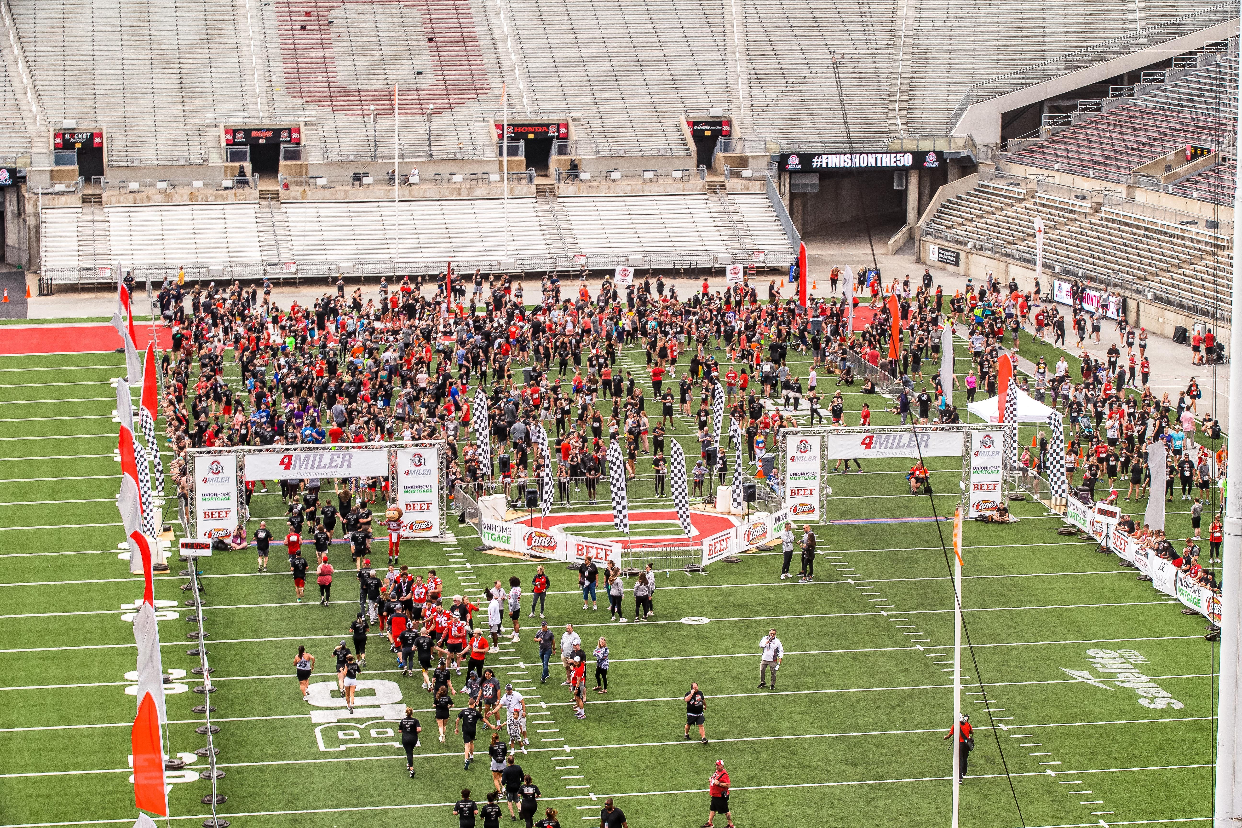 Previous "The Ohio State 4 Miler" participants finish the race by crossing the Ohio Stadium's 50-yard line. Credit: M3S Sports