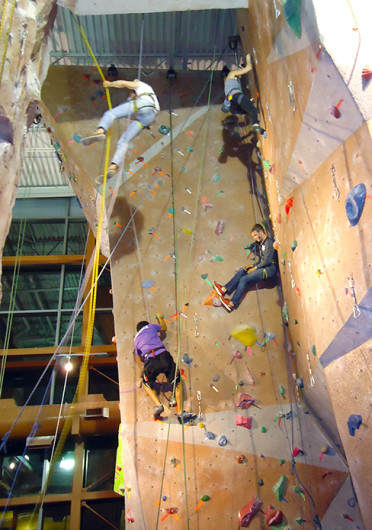 Students Amit Raghvanshi (bottom left) and Krista Bryson (top right) race past zombies on the climbing wall for the Outdoor Adventure Center’s Zombie Climbing Competition on Oct. 13.  Credit: Nick Roll / Lantern reporter 