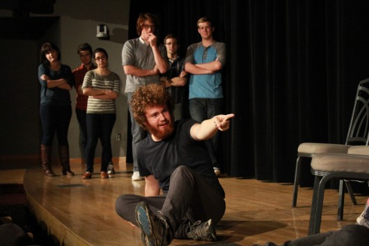 Fourth-year in biomedical engineering, Stephen Doughten, sits on stage as other Fishbowl Improv members look on at the Bellwether Improv Festival Nov. 8.
