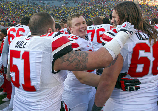 Redshirt-freshman right guard Pat Elflein (65) celebrates with junior defensive lineman Joel Hale (51) and sophomore right tackle Taylor Decker (68) after a game against Michigan Nov. 30 at Michigan Stadium. OSU won, 42-41. Credit: Shelby Lum / Photo editor