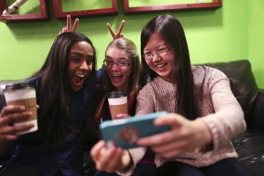 Friends Amrita Mohanty, 16, (left), Marta Williams, 16, and Michelle Mao, 15, take a Snapchat 'selfie' while having coffee at the Steepery Tea Bar in Woodbury, Minn., Dec. 12, 2013. Credit: Courtesy of MCT