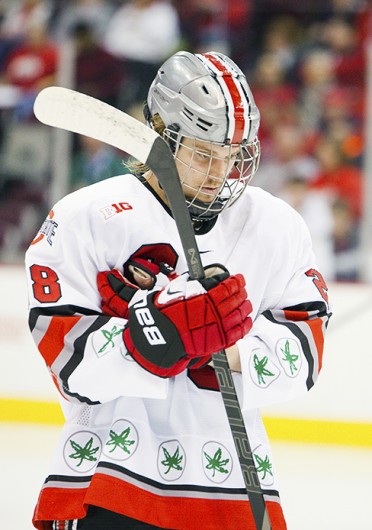 Senior forward Alex Szczechura takes off his gloves during a game against Michigan State Jan. 11 at the Schottenstein Center. The teams tied, 1-1. Credit: Kelly Roderick / For The Lantern
