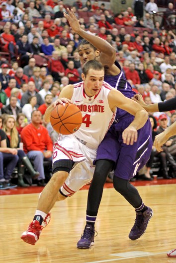 Senior guard Aaron Craft (4) drives past an opponent during a game against Northwestern Feb. 19 at the Schottenstein Center. OSU won, 76-60. Credit: Shelby Lum / Photo editor