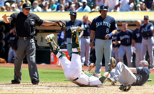 Seattle Mariners outfielder Dustin Ackley (right) is called safe at home after a collision with Oakland Athletics catcher Stephen Vogt (middle) Aug. 21 at O.co Coliseum. Seattle won, 5-3. Courtesy of MCT