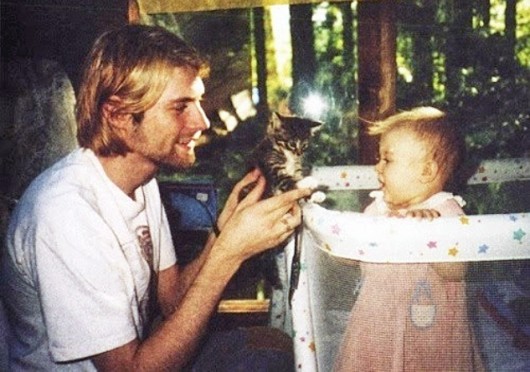 Kurt Cobain (left), the former frontman of Nirvana, holds up a kitten to his daughter, Frances Bean Cobain. 