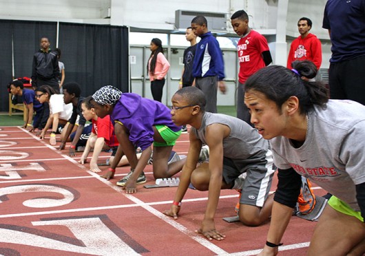 OSU LiFESports counselor Tarkington Newman (bottom right) gets set to race kids who participated in the track & field clinic held March 29 at French Field House. Credit: Matt Homan / Lantern reporter