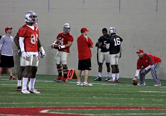 Senior quarterback Braxton Miller (5) talks with offensive coordinator and quarterbacks coach Tom Herman and redshirt-freshman quarterback J.T. Barrett (16) during spring practice March 4 at the Woody Hayes Athletic Center. Credit: Shelby Lum / Photo editor