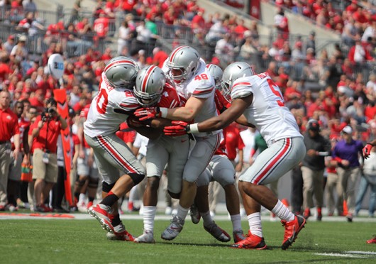 Members of the Gray defense swarm Scarlet H-back Curtis Samuel (4) during the 2014 Spring Game April 12 at Ohio Stadium. Gray won, 17-7. Credit: Shelby Lum / Photo editor
