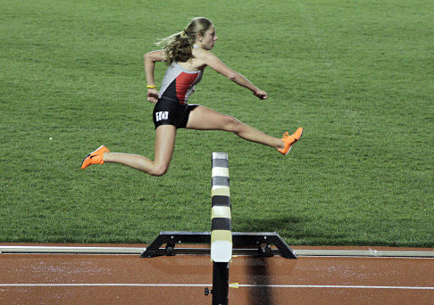 Junior distance runner Nicole Hilton jumps a fence during the 3000-meter steeplechase as part of the Jesse Owens Track Classic April 19 at Jesse Owens Memorial Stadium. Hilton won  the race. Courtesy of OSU Athletics