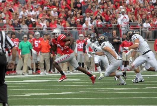 OSU redshirt-sophomore wide receiver Michael Thomas sprints away from Kent State defenders on his way to the endzone Saturday.  OSU won 66-0. Credit: Mark Batke / Photo editor