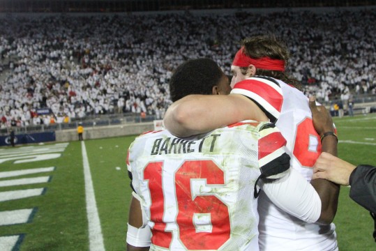 Sophomore defensive lineman Joey Bosa (right) hugs redshirt-freshman quarterback J.T. Barrett following a game against Penn State on Oct. 25 in State College, Pa. OSU won in double-overtime, 31-24. Credit: Mark Batke / Photo editor