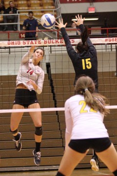 OSU junior outside hitter Elizabeth Campbell (14) attempts to spike the ball past Iowa junior outside hitter Julianne Blomberg (15) during a Nov. 19 match at St. John Arena. OSU won, 3-0. Credit: Ed Momot / For The Lantern