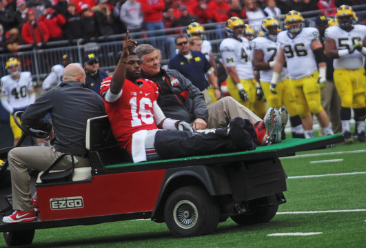 Redshirt-freshman quarterback J.T. Barrett (16) is carted away after suffering a right ankle fracture during the 4th quarter of a game against Michigan on Nov. 29 at Ohio Stadium. OSU won, 42-28. Credit: Chelsea Spears / Multimedia editor