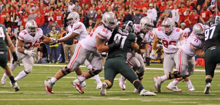 Members of the OSU offense attempt to move the ball downfield during the 2013 Big Ten championship game against Michigan State Dec. 7. at Lucas Oil Stadium. OSU lost, 34-24. Credit: Lantern file photo