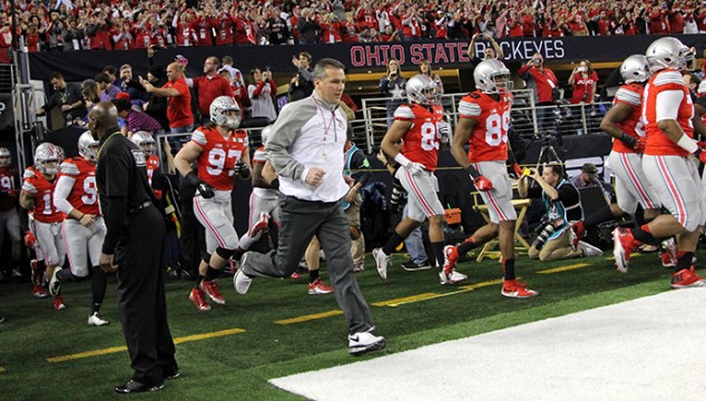 Coach Urban Meyer leads the OSU football team onto the field at AT&T Stadium before the College Football Playoff National Championship game against Oregon in Arlington, Texas. OSU won, 42-20.  Credit: Mark Batke / Photo editor