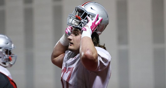 Junior defensive lineman Joey Bosa put on his helmet during a March 26 practice at the Woody Hayes Athletic Center. Credit: Lantern file photo