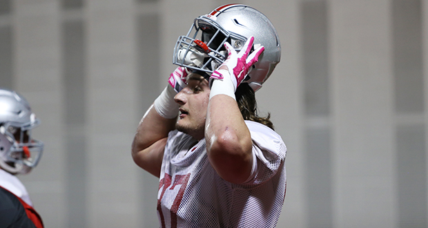 Junior defensive lineman Joey Bosa put on his helmet during a March 26 practice at the Woody Hayes Athletic Center. Credit: Mark Batke / Photo editor