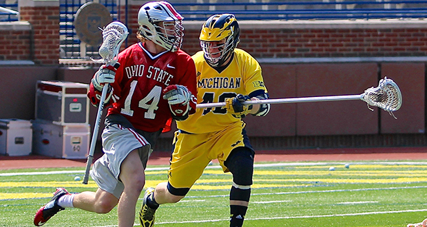 OSU junior attacker Carter Brown (14) attempts to move past a Michigan defender during an April 12 game in Ann Arbor, Mich. OSU won, 13-8. Credit: Molly Tavoletti / Lantern Reporter