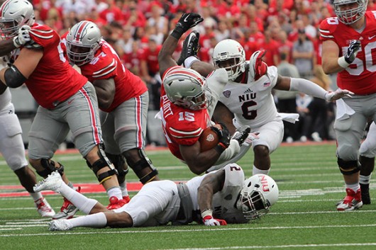 OSU junior running back Ezekiel Elliott (15) falls to the ground after a carry in a game against Northern Illinois on Sept. 19 at Ohio Stadium. OSU won, 20-13. Credit: Samantha Hollingshead / Photo Editor