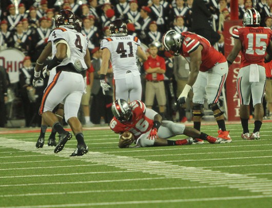 Then-redshirt freshman quarterback J.T. Barrett (16) lies on the ground after being tackled during a game against Virginia Tech Sept. 6 at Ohio Stadium. OSU lost, 35-21. Credit: Lantern File Photo