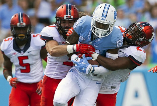North Carolina's Bug Howard (84) romps for 27 yards after a pass reception in the third quarter as Illinois' Eaton Spence (27) and Taylor Barton (3) try to bring him down on Saturday, Sept. 19, 2015, at Kenan Stadium in Chapel Hill, N.C. Credit: Courtesy of TNS 