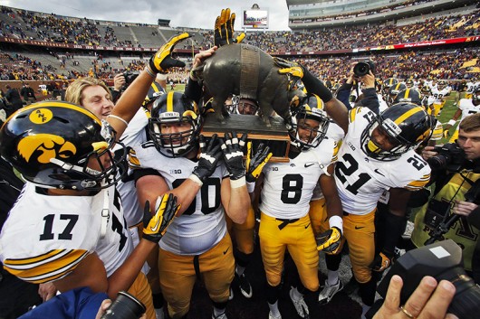 Iowa players carry Floyd of Rosedale, the game trophy, off the field following a 23-7 victory over Minnesota at TCF Bank Stadium in Minneapolis on Sept. 28, 2013. Credit: Courtesy of TNS