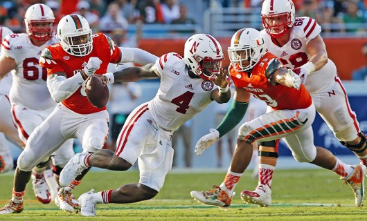 Miami's Al-Quadin Muhammad (8) and Trent Harris (33) chase and sack Nebraska quarterback Tommy Armstrong Jr. (4) in the third quarter at Sun Life Stadium in Miami Gardens, Fla., on Sept. 19. Miami won, 36-33, in overtime. Credit: Courtesy of TNS