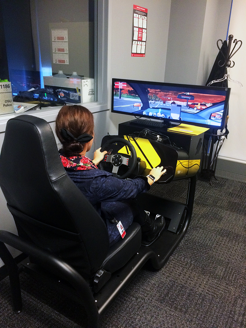 OSU Coordinator for Student Life Ally Himes tests out the driving simulator. Credit: Aubrey Cornwell