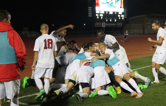 The Ohio State men's soccer team piles on top of midfielder Christian Soldat (13) after he scores the game winning goal with 3 seconds remaining in the second period of extra time during the men's soccer game against Bowling Green State University at Jesse Owens Memorial Stadium in Columbus, Ohio on October 7, 2015. OSU won 2-1. Eric Weitz / Lantern Photographer